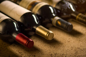 Set of red dry wine bottles on cork background. Low depth of field.